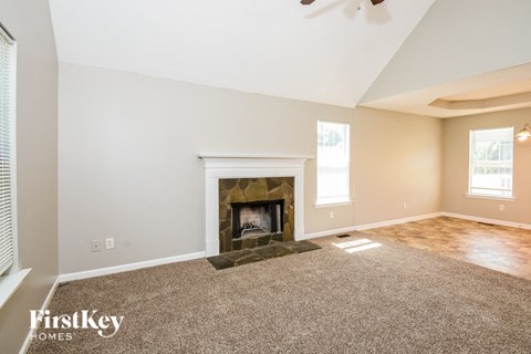 the living room has a fireplace and carpeted flooring