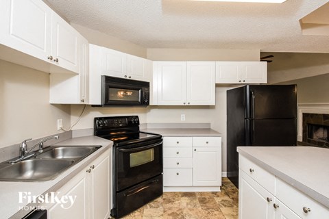 a kitchen with black appliances and white cabinets