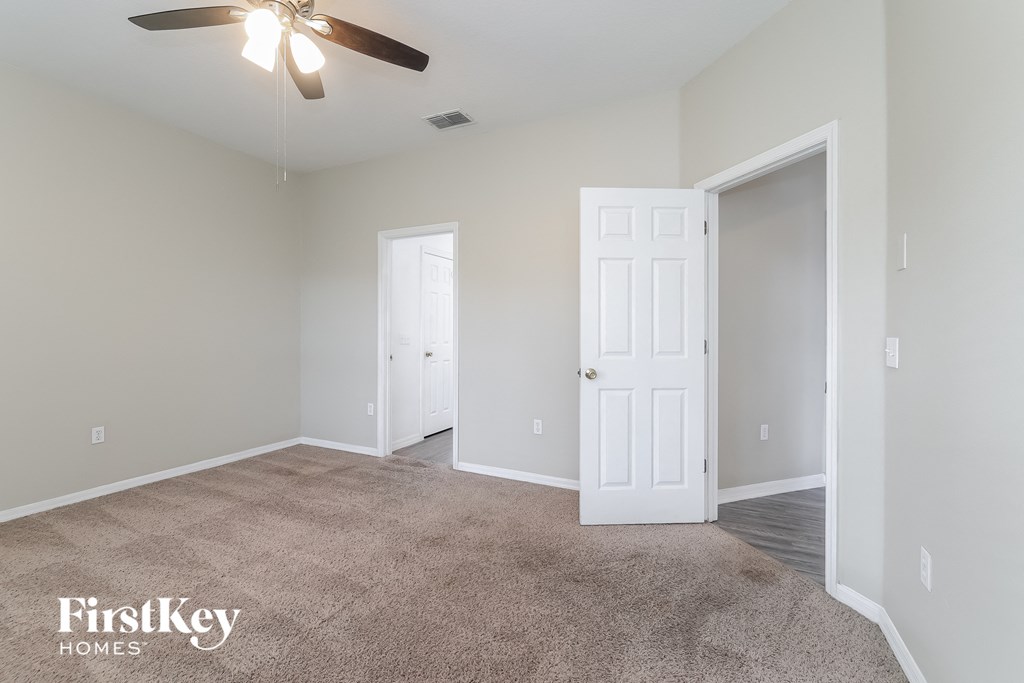 a living room with carpet and a ceiling fan