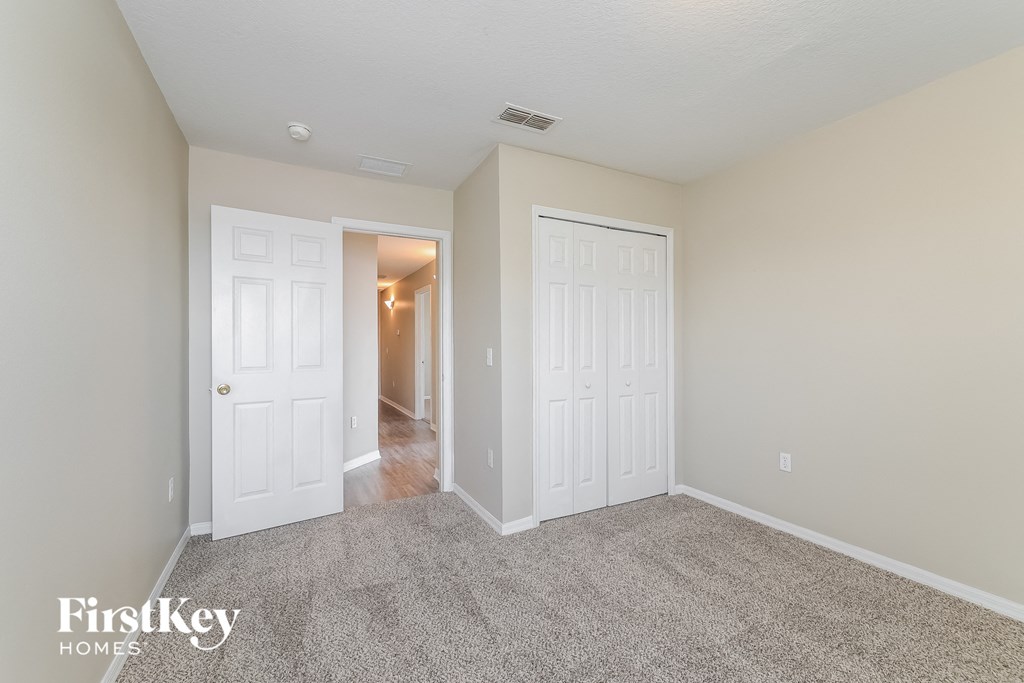 a bedroom with two closets and a door to a hallway