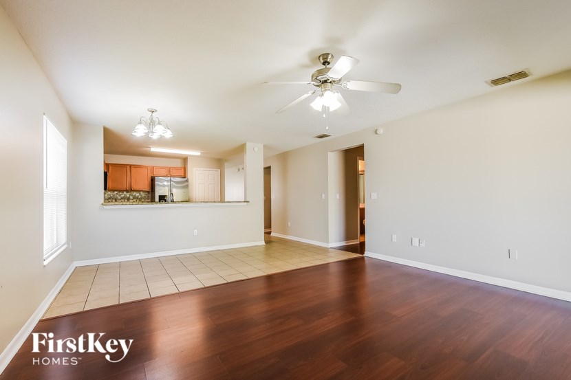 A spacious room with a ceiling fan and wooden flooring.