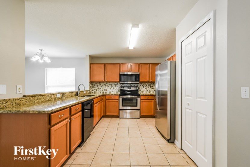 A kitchen with brown cabinets and a stainless steel refrigerator.