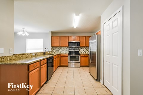 A kitchen with brown cabinets and a stainless steel refrigerator.