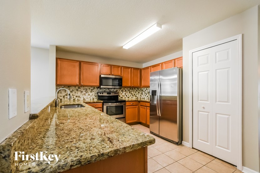 A kitchen with granite countertops and a refrigerator.