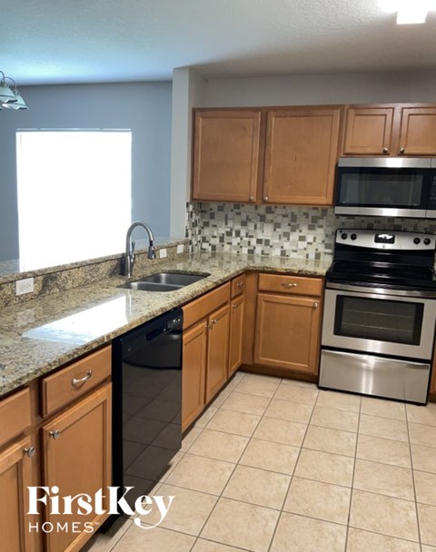 A kitchen with wooden cabinets and a granite countertop.