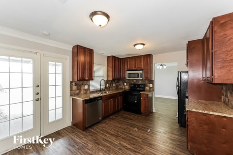 A kitchen with wooden cabinets and a stainless steel dishwasher.