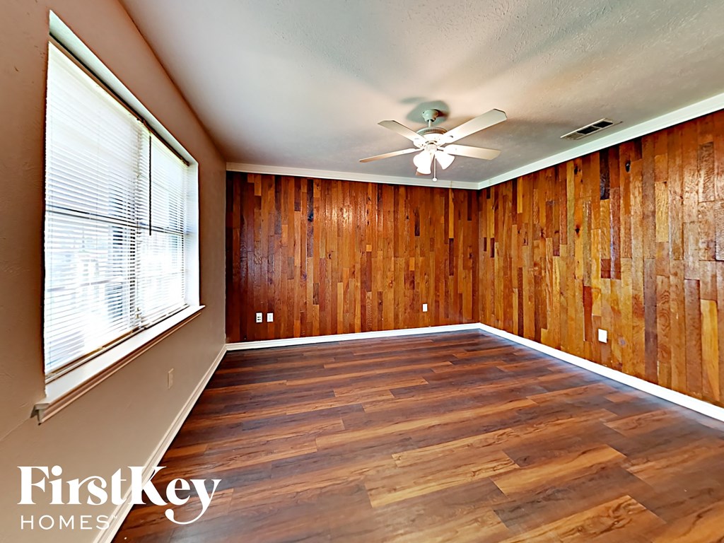 A room with wooden walls and a ceiling fan.