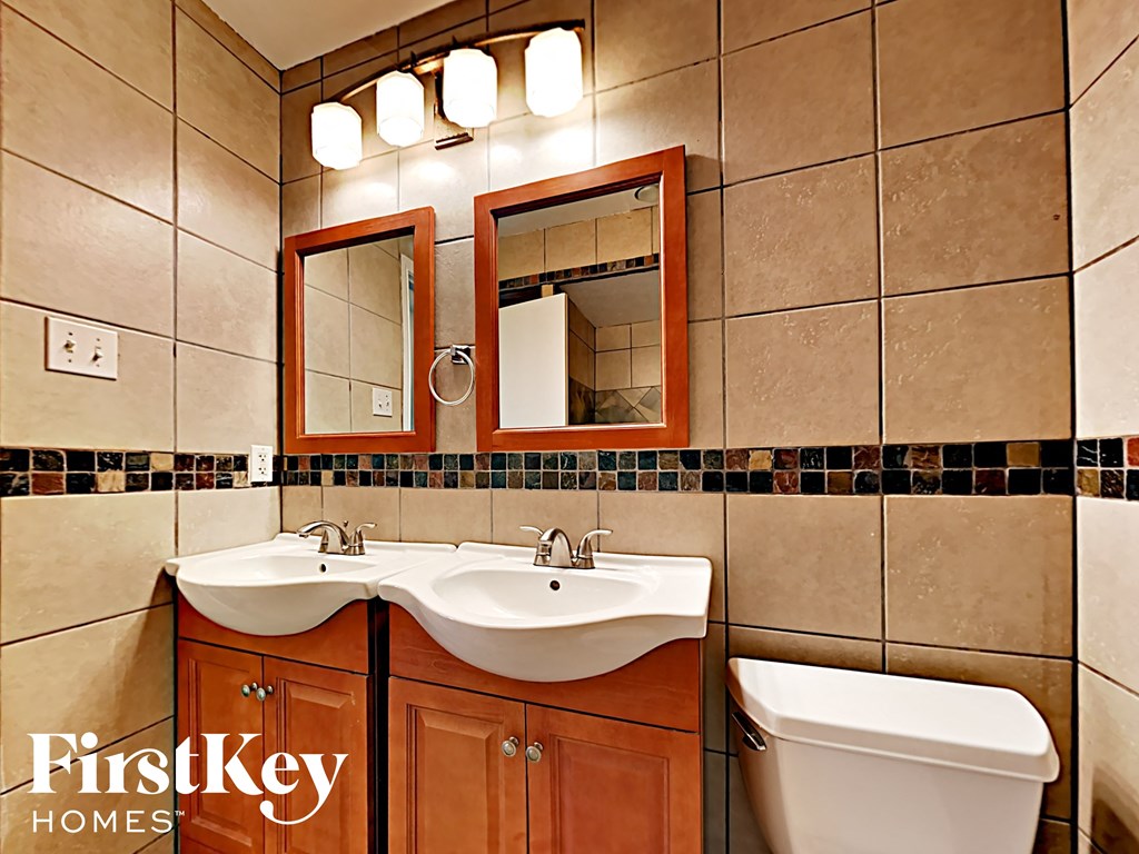 A bathroom with a brown vanity and a white toilet.
