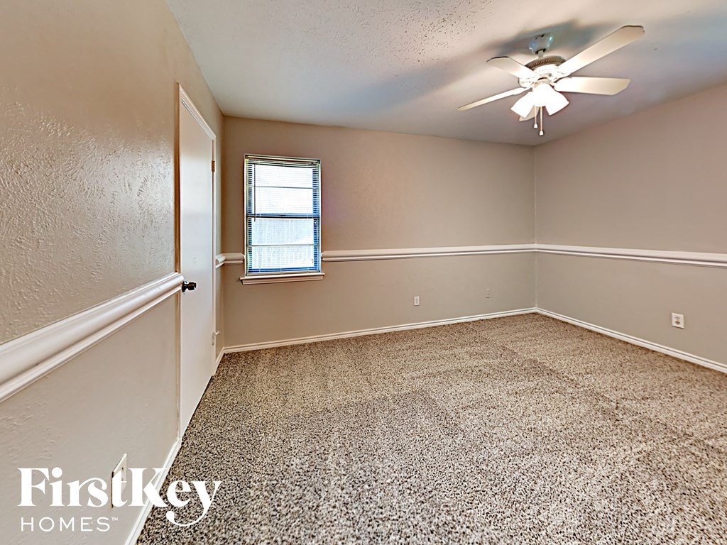 A room with a ceiling fan and a window.