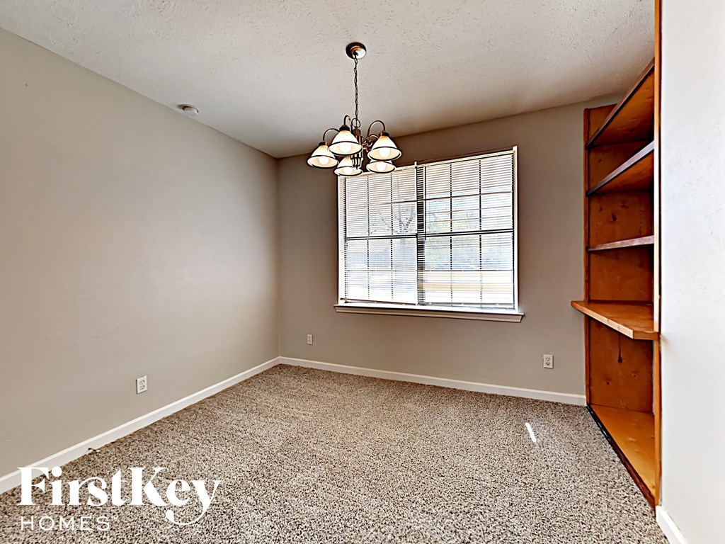 A room with a window and a wooden staircase.