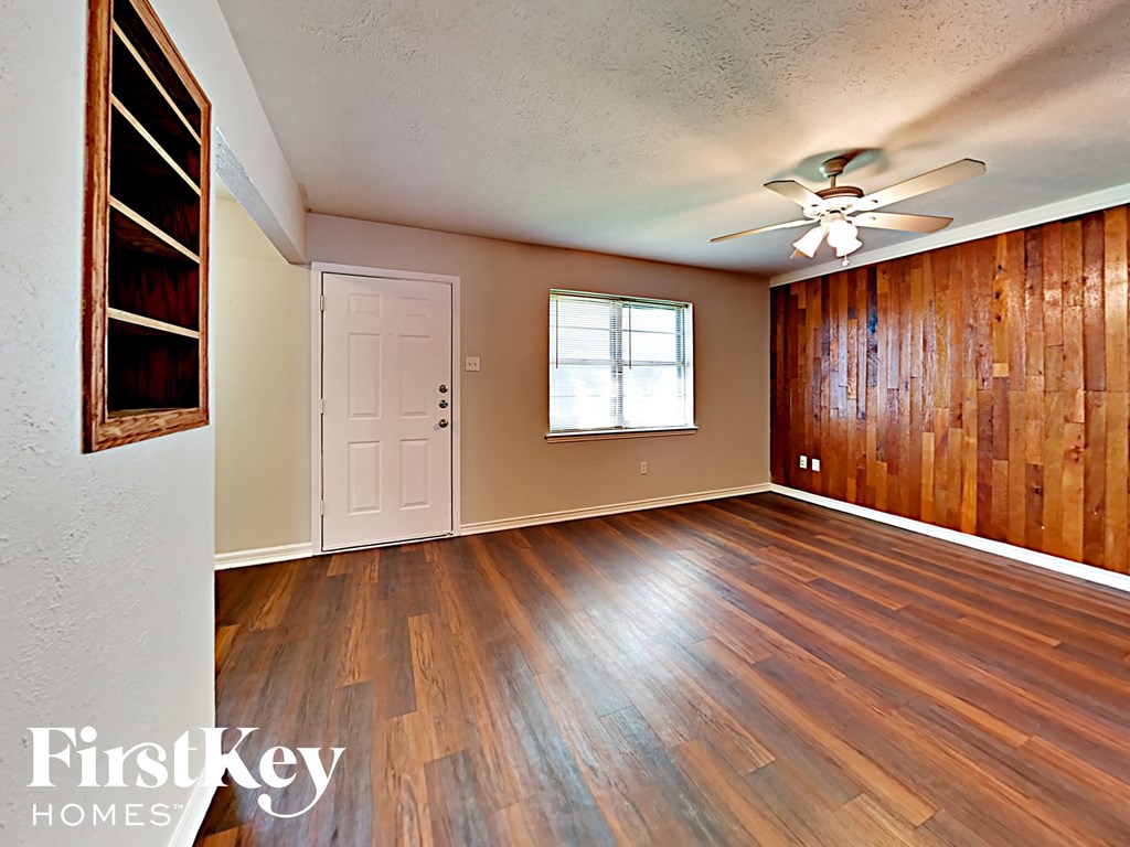 A room with wooden floors and a ceiling fan.