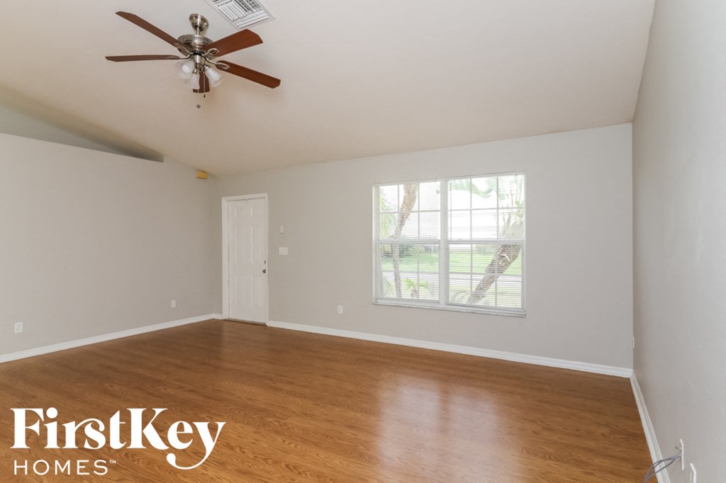 a living room with wood floors and a ceiling fan