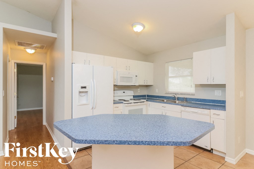 a kitchen with white cabinets and a blue counter top