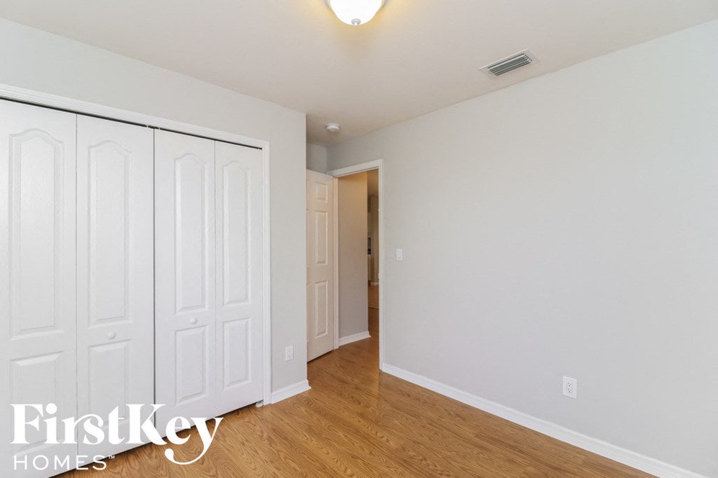 a bedroom with two closets and a door to a hallway