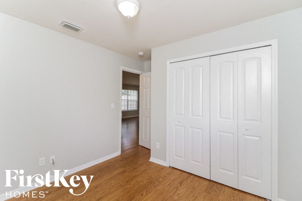 a bedroom with two closets and a hard wood floor