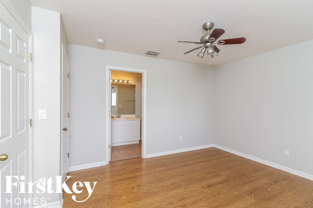a living room with white walls and a ceiling fan