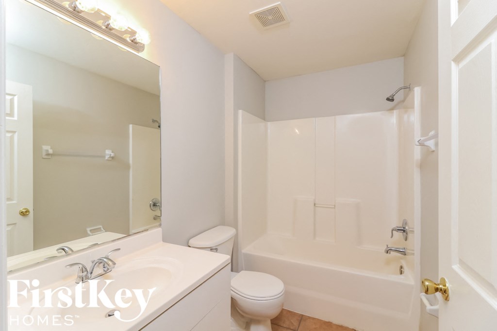 a white bathroom with a toilet and a tub and a sink