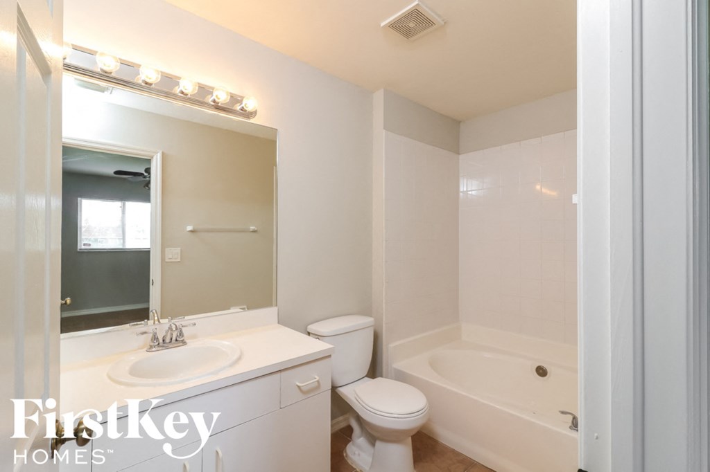 a bathroom with a sink toilet and a tub and a mirror