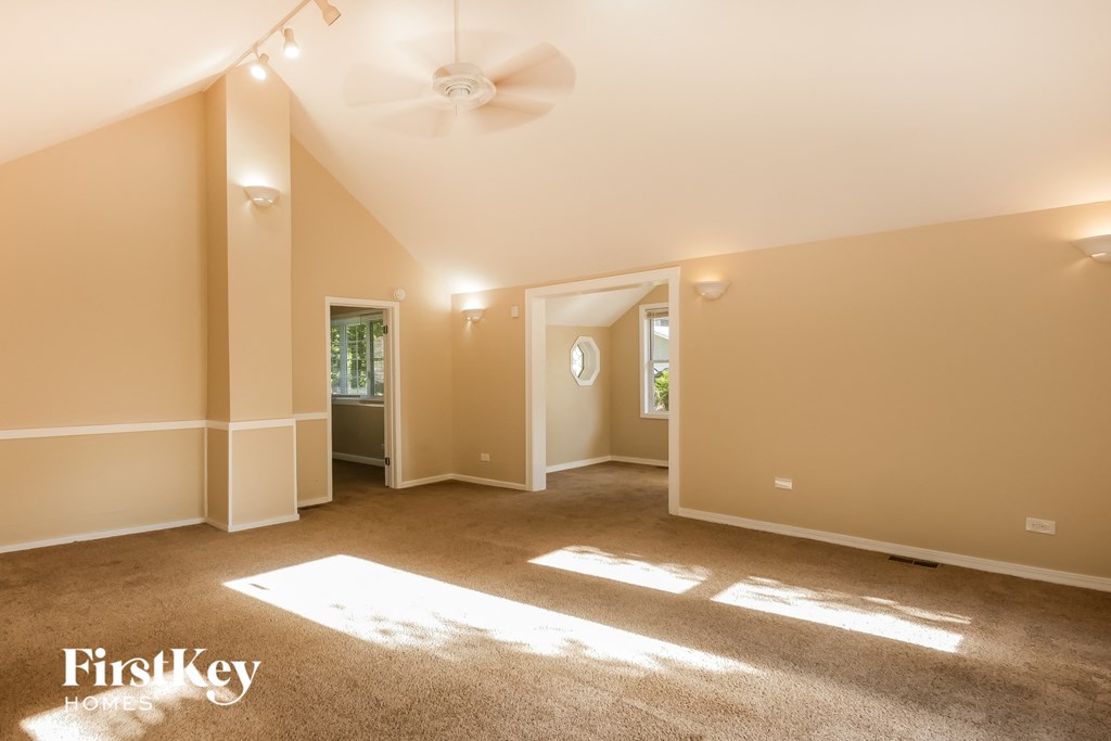 an empty living room with a ceiling fan