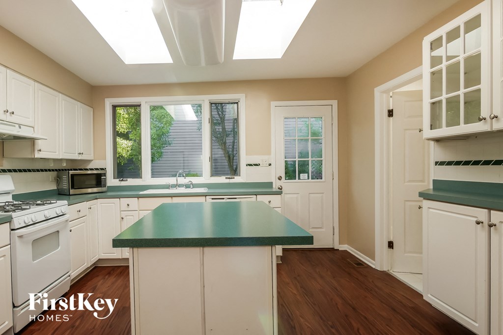 a kitchen with white cabinets and a green counter top