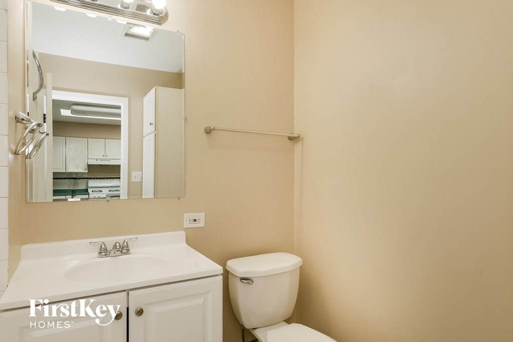 a bathroom with a toilet and a sink and a mirror