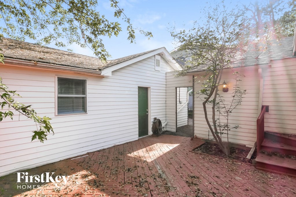a small white house with a cat sitting in the yard