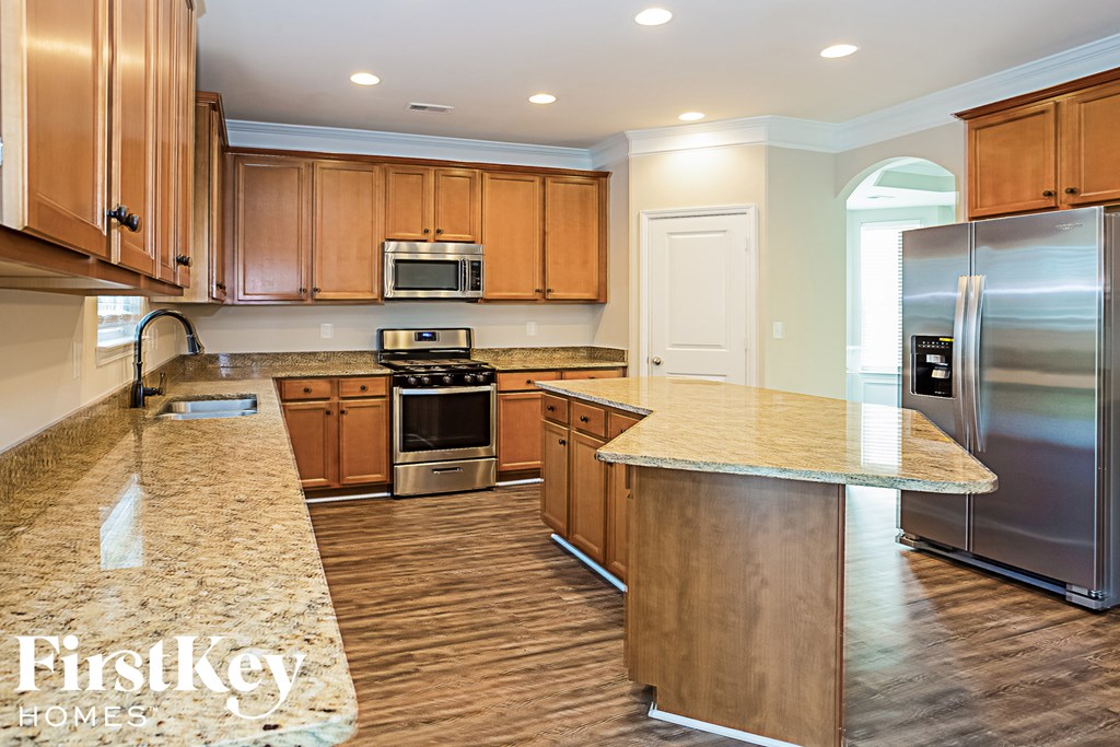 A kitchen with wooden cabinets and granite countertops.