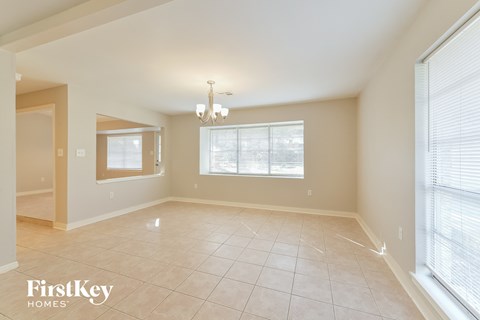 A spacious room with a chandelier and large windows.