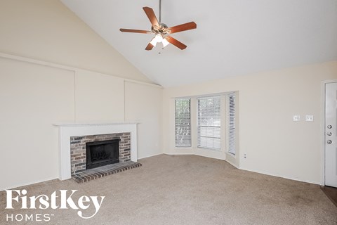 A room with a fireplace and a ceiling fan.