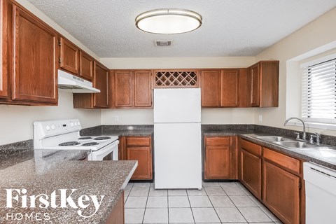 A kitchen with brown cabinets and a white refrigerator.