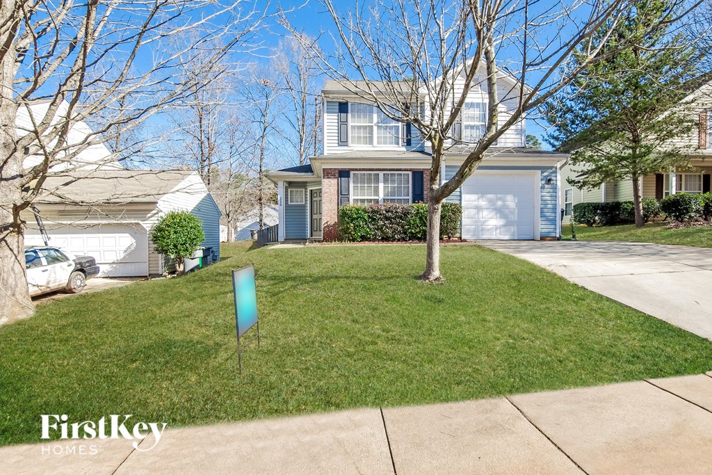 a home with a lawn and trees in front of it