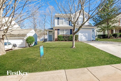 a home with a lawn and trees in front of it