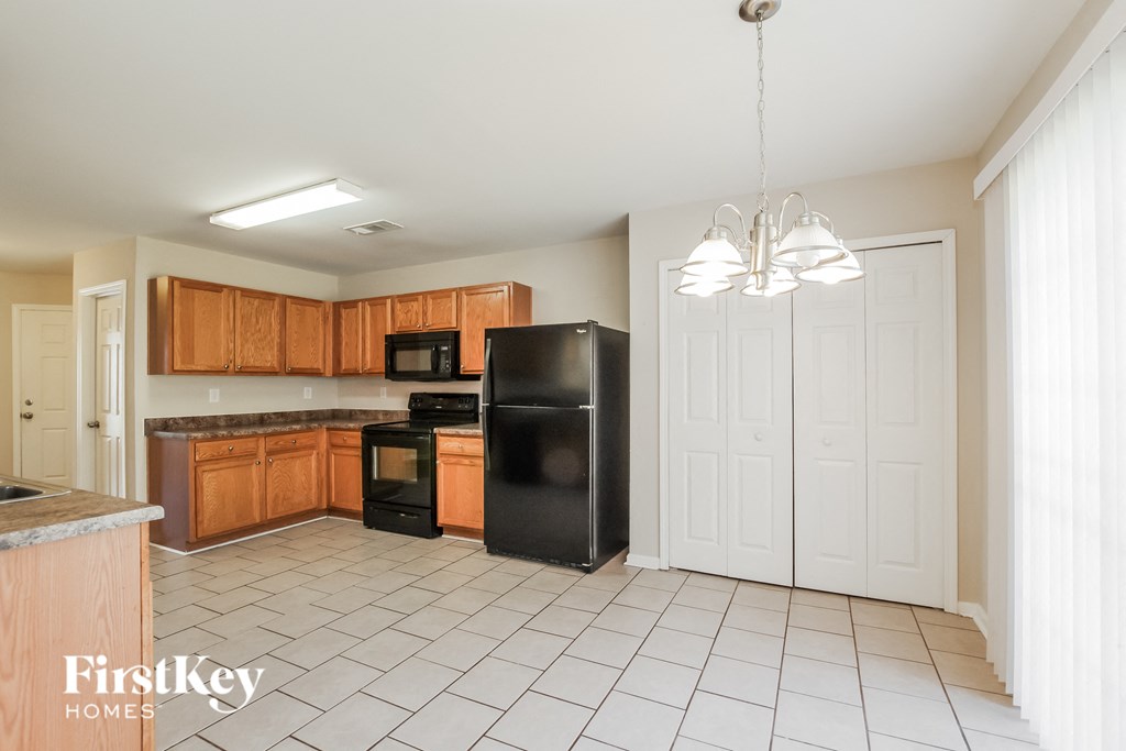 a kitchen with wooden cabinets and a black refrigerator
