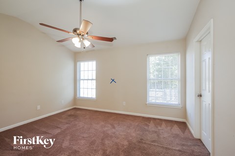 a living room with carpet and a ceiling fan
