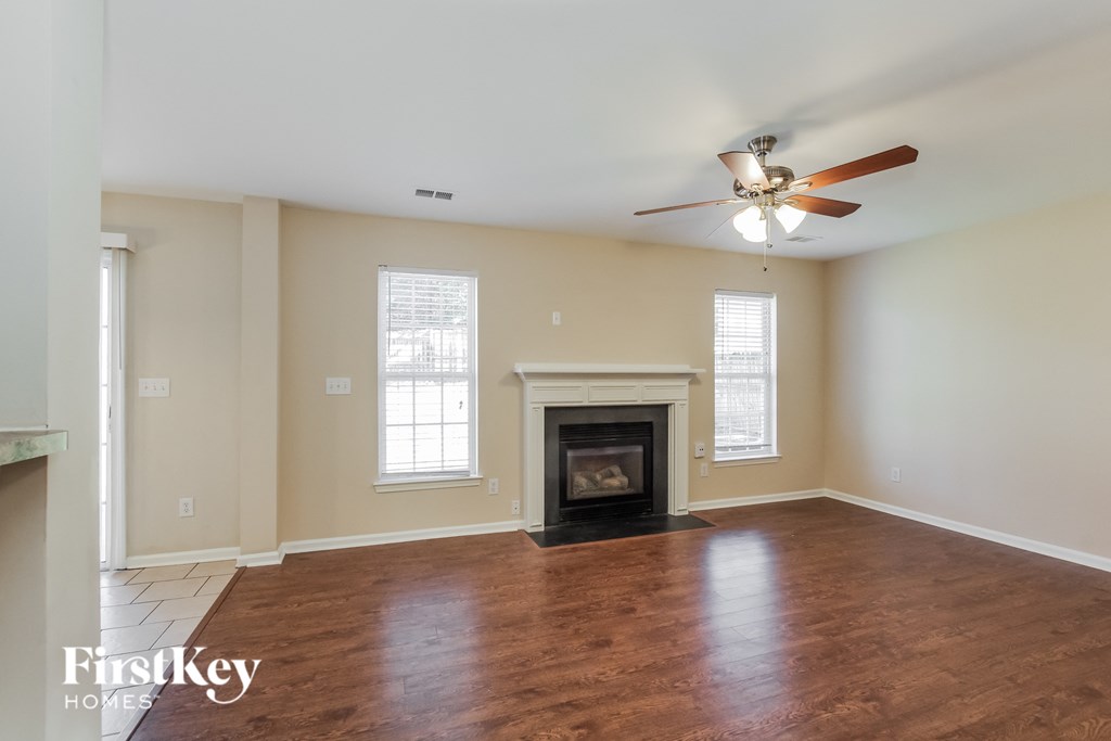 a living room with a fireplace and a ceiling fan
