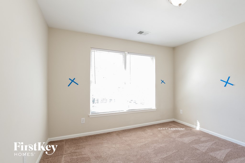 a bedroom with blue x marks on the wall and a window