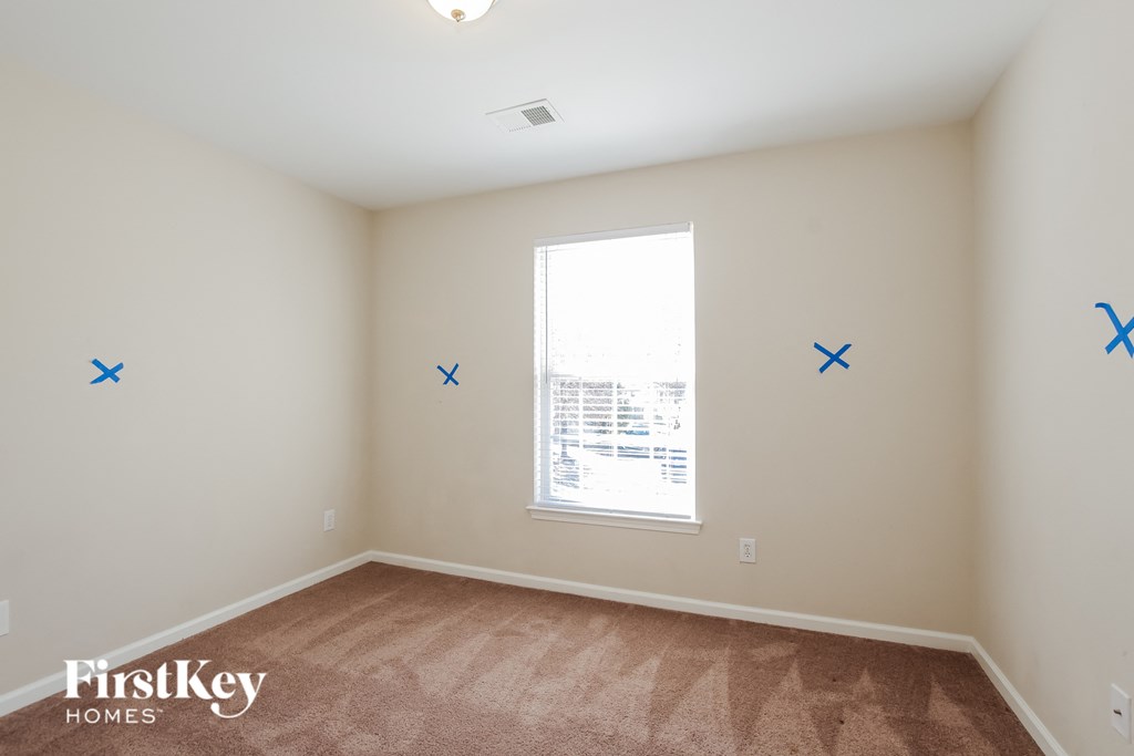 an empty room with blue x on the walls and a window