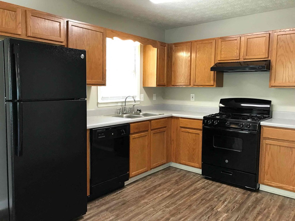 a kitchen with black appliances and wooden cabinets
