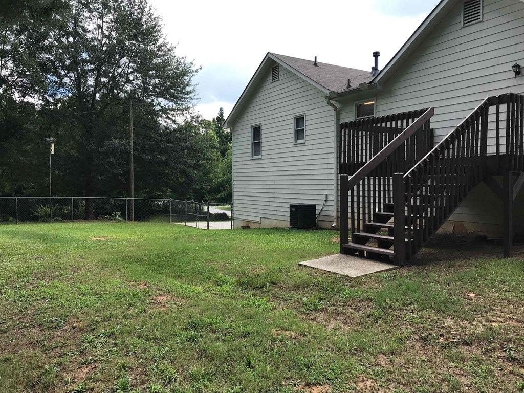 a backyard with a deck and a house with a staircase