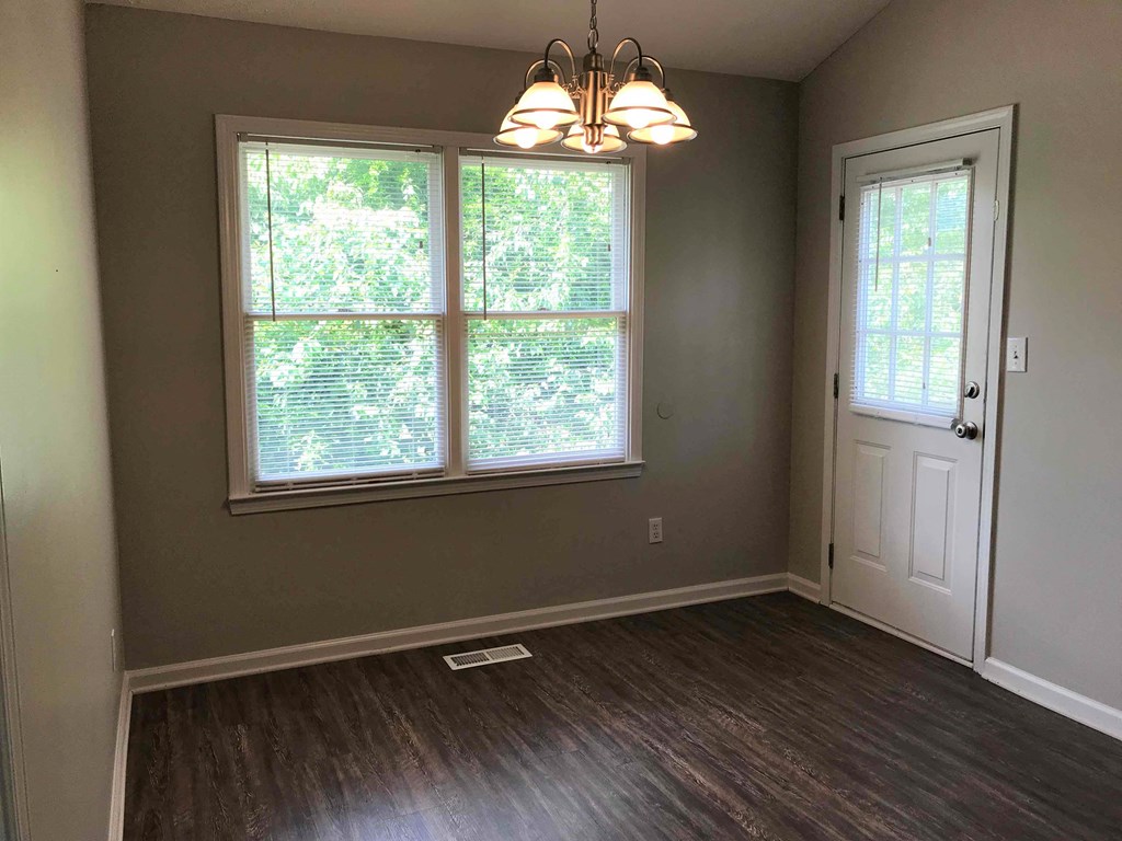 an empty living room with a window and a door