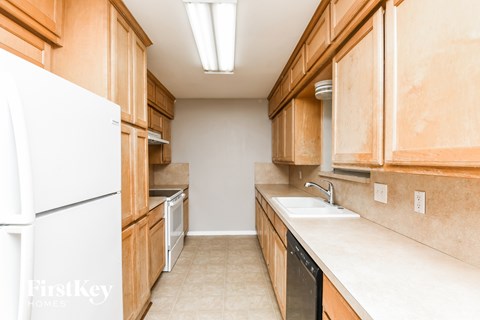 A kitchen with wooden cabinets and a white refrigerator.