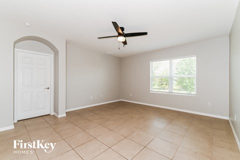 A spacious room with a fan and a door.