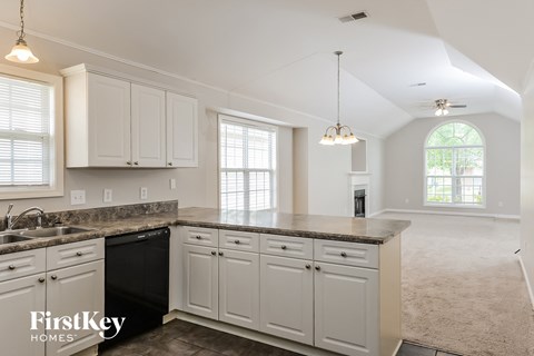 A kitchen with white cabinets and a black dishwasher.