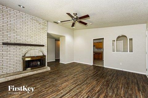 A room with a brick wall and wooden floors.