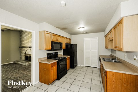 A kitchen with wooden cabinets and black appliances.