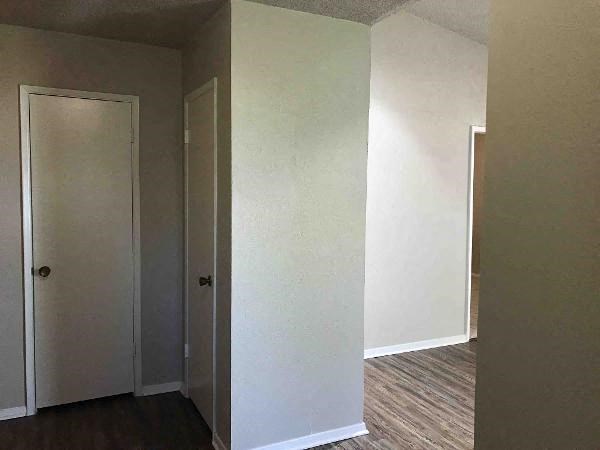 A hallway with two doors and a wooden floor.