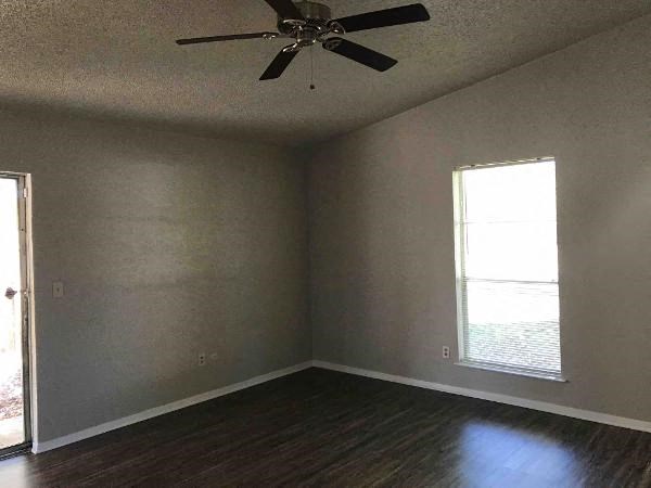 A room with a ceiling fan and a window.