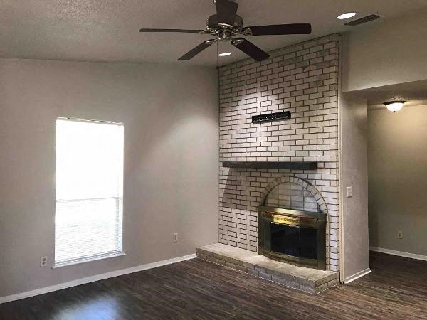 A room with a fireplace and a ceiling fan.