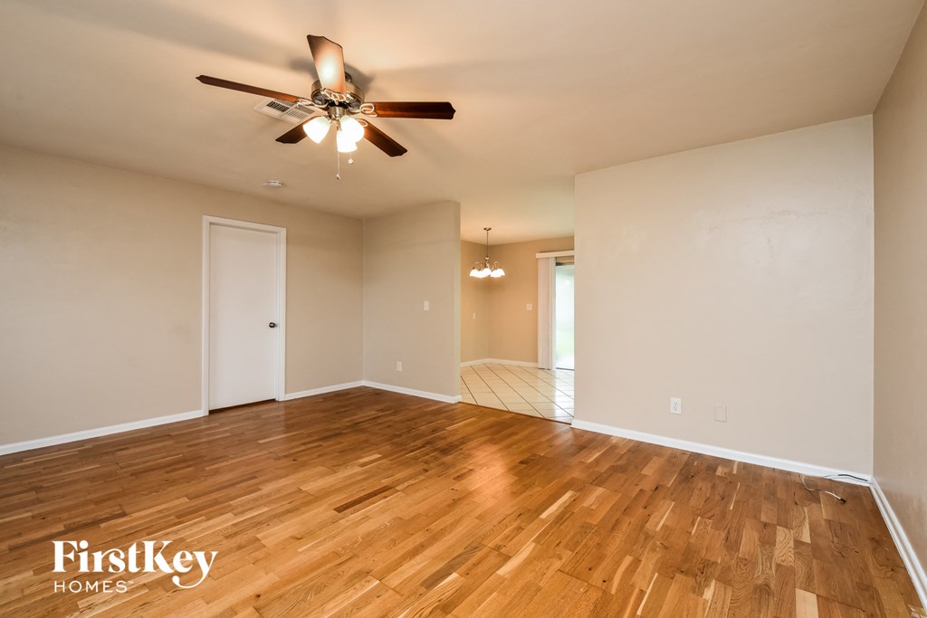 A room with wooden floors and a ceiling fan.