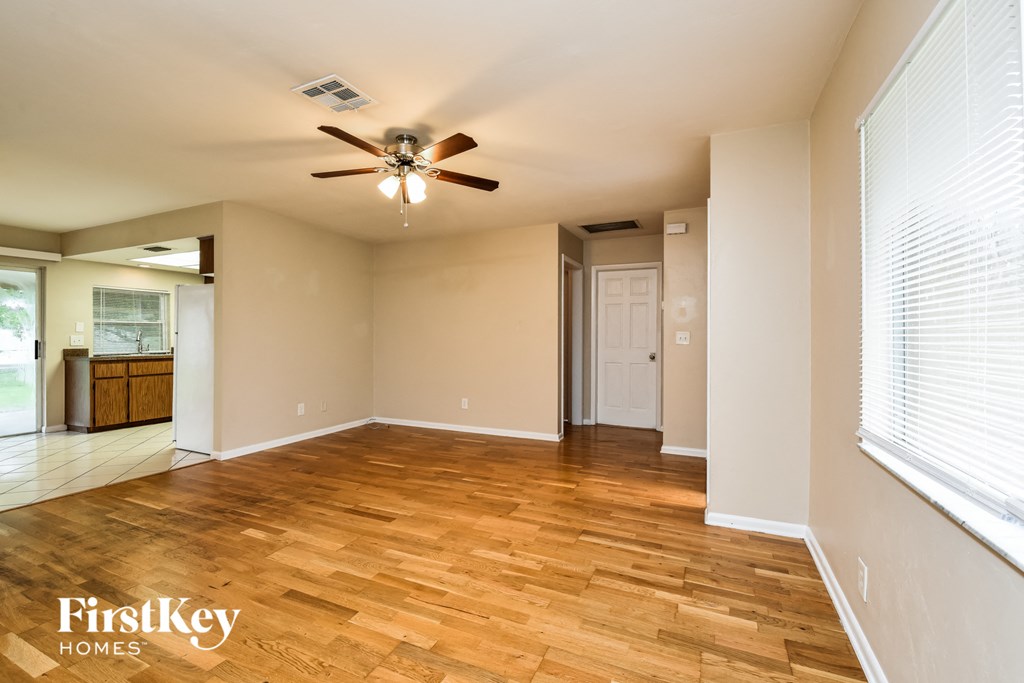 A room with wooden floors and a ceiling fan.